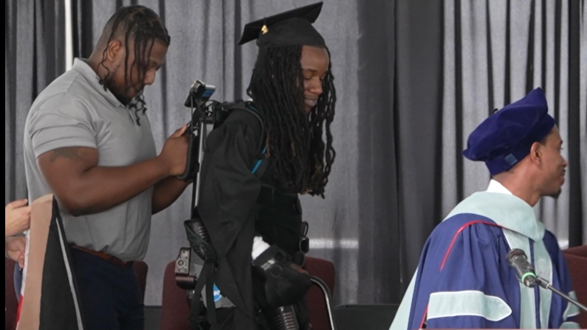 Paralyzed graduate walks across stage with robotic suit to earn MA ...
