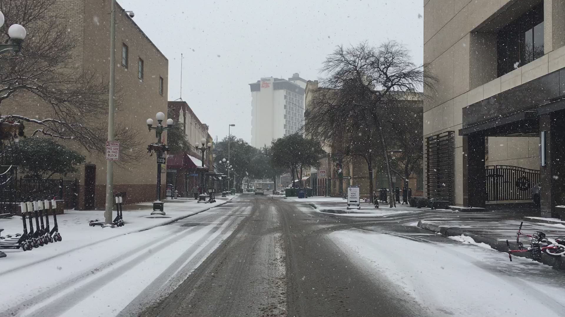 Check out the snow falling in downtown San Antonio! The snow is blanketing the ground.