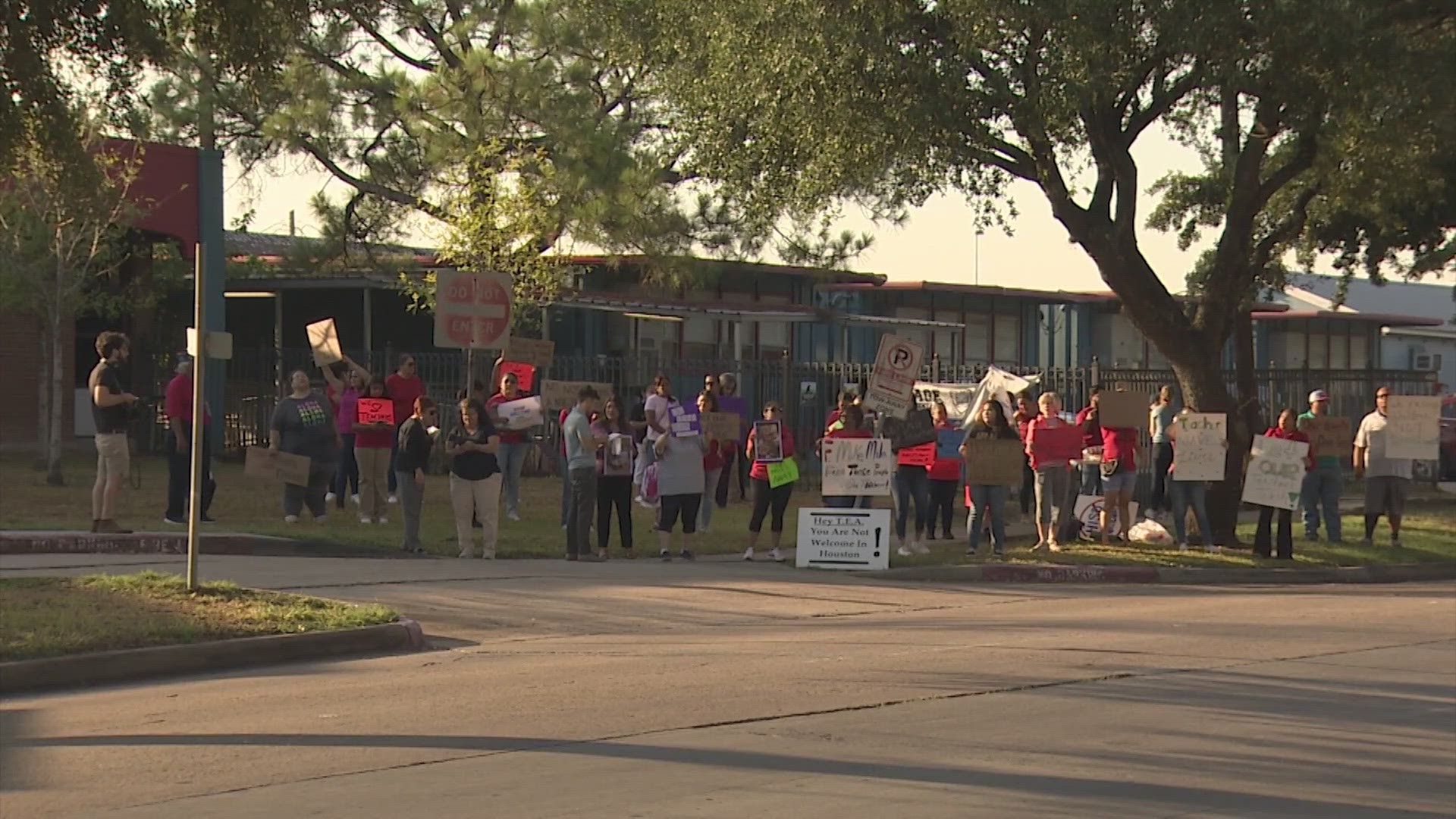 The parents protested outside Cage Elementary and Project Chrysalis Middle School in support of a fired teacher and other staff members.