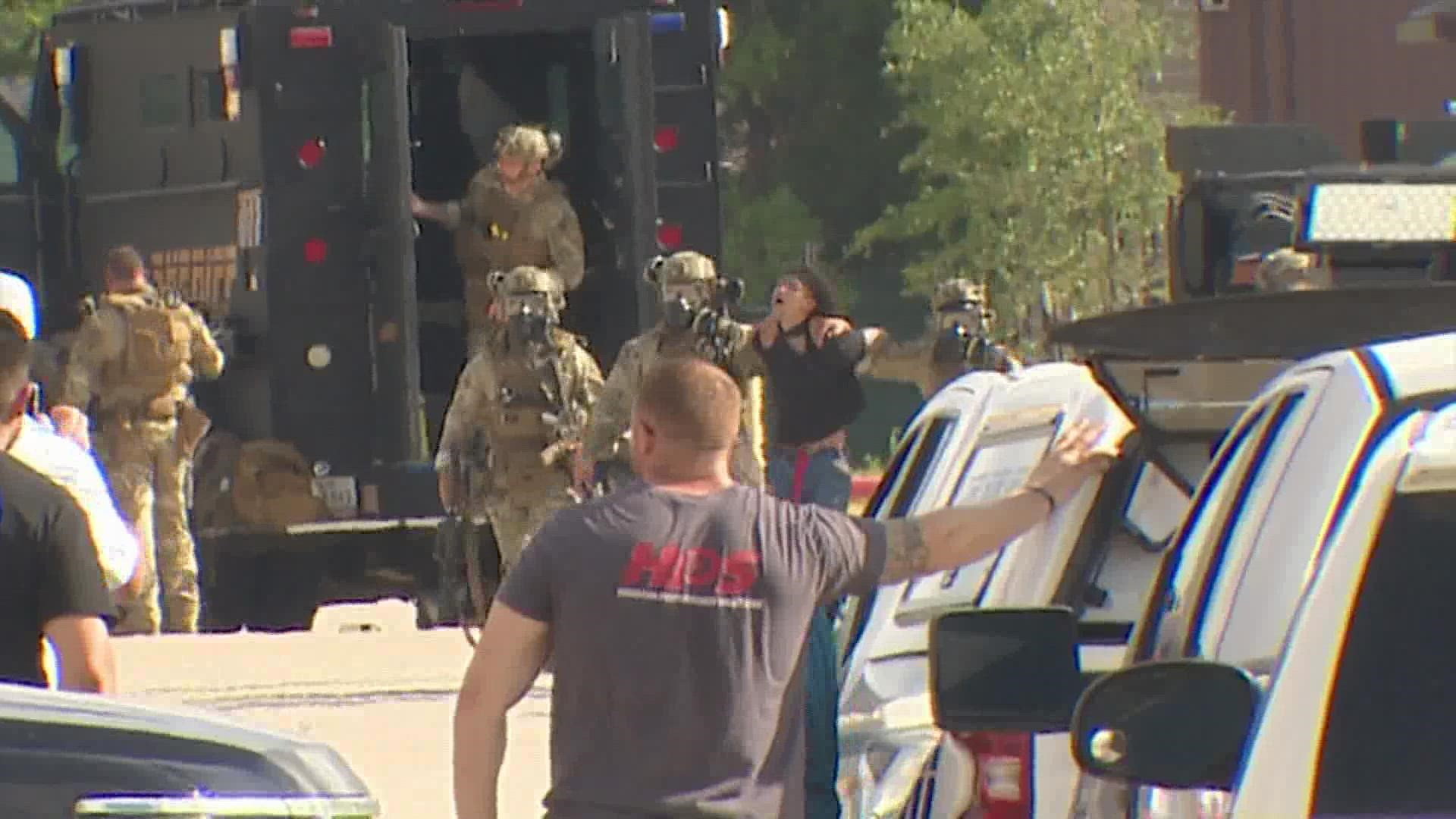SWAT sent in a robot around 7 a.m. that spotted the suspect still inside a warehouse located behind a motel off FM 529. They later used tear gas.