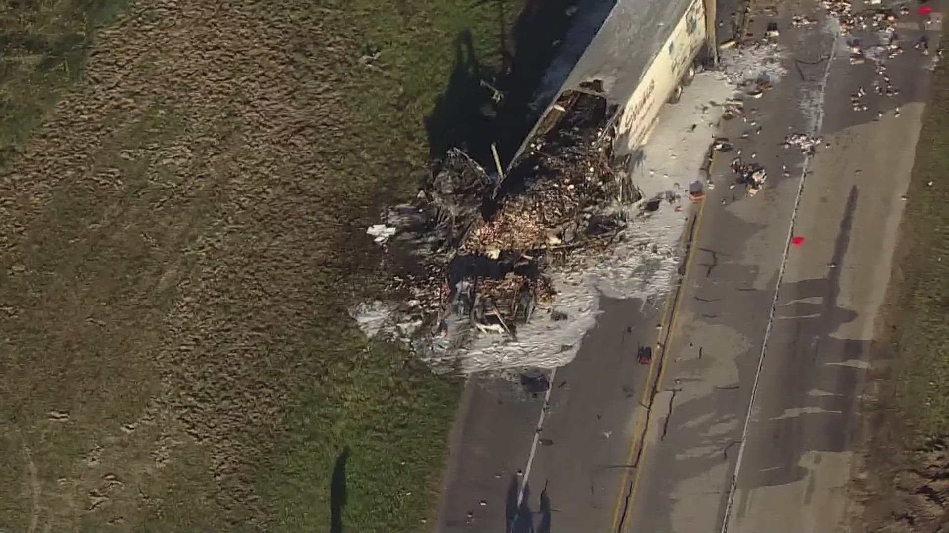 Aerial views from Air 11 show the cab of the truck and the front end of the trailer destroyed by fire.