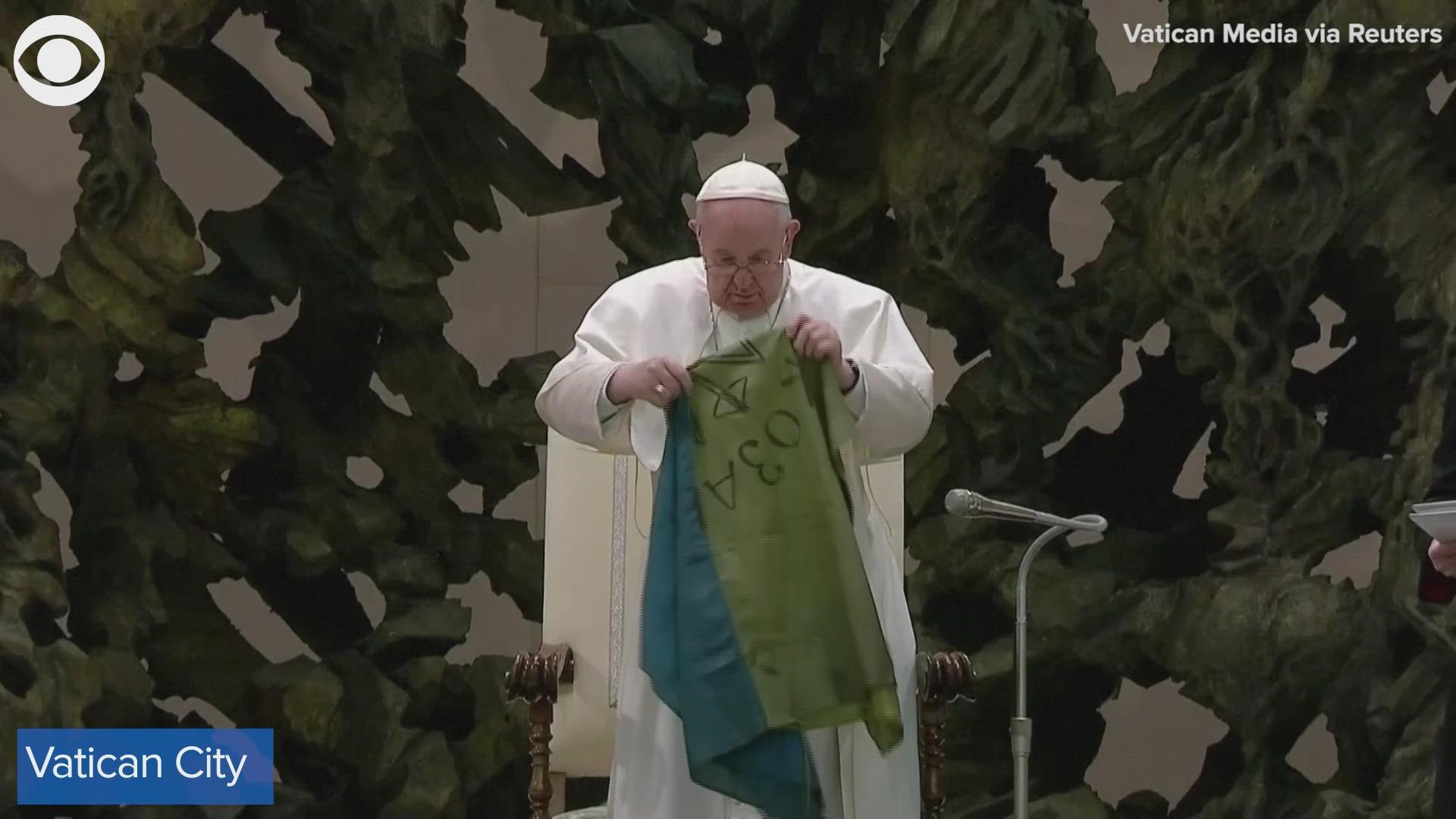 The Pope said the flag comes from the city of Bucha and also invited Ukrainian refugee children to stand with him.