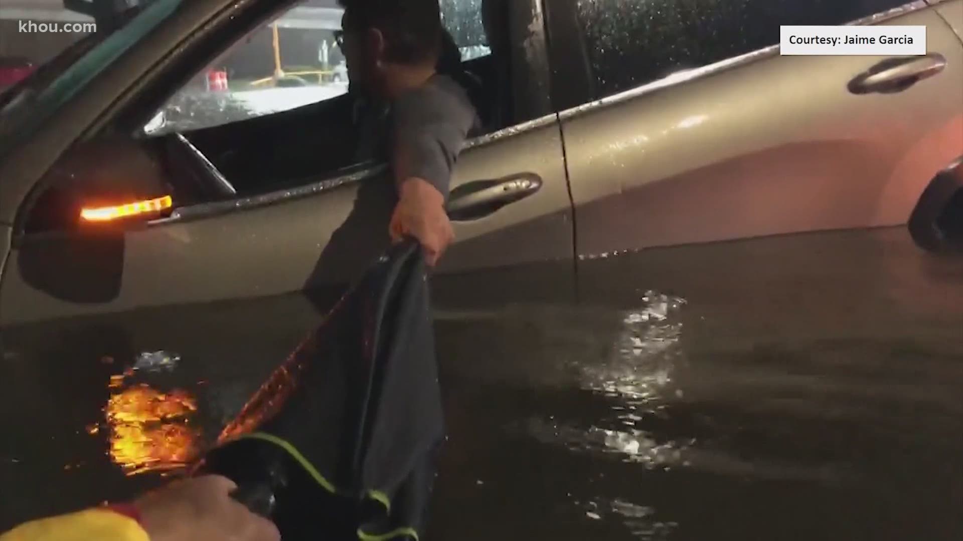 Pastor Jaime Garcia helps bring a driver to safety after Tropical Depression Beta causes intense flooding in the southern parts of Houston.