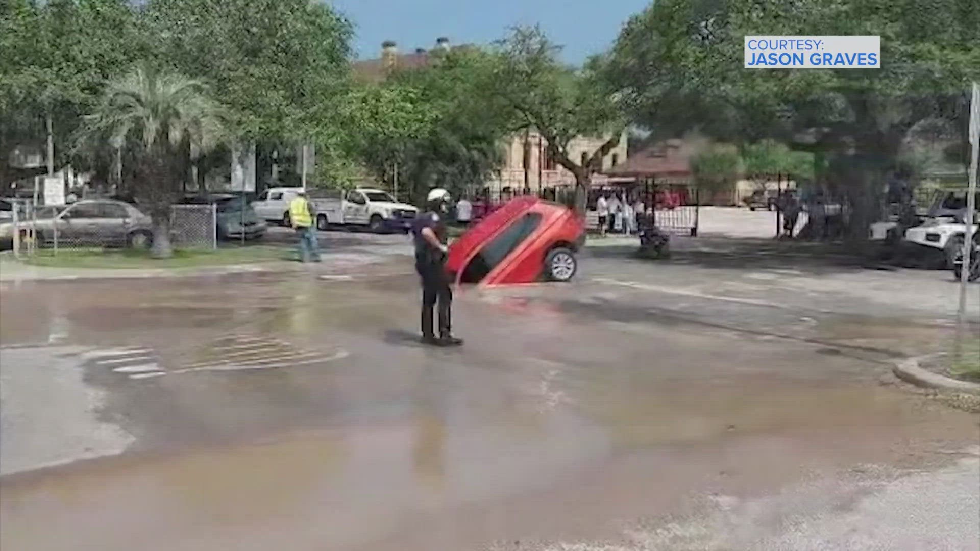 It was a bad day Tuesday for a driver who ended up partially submerged in a giant sinkhole in Galveston, according to city officials.