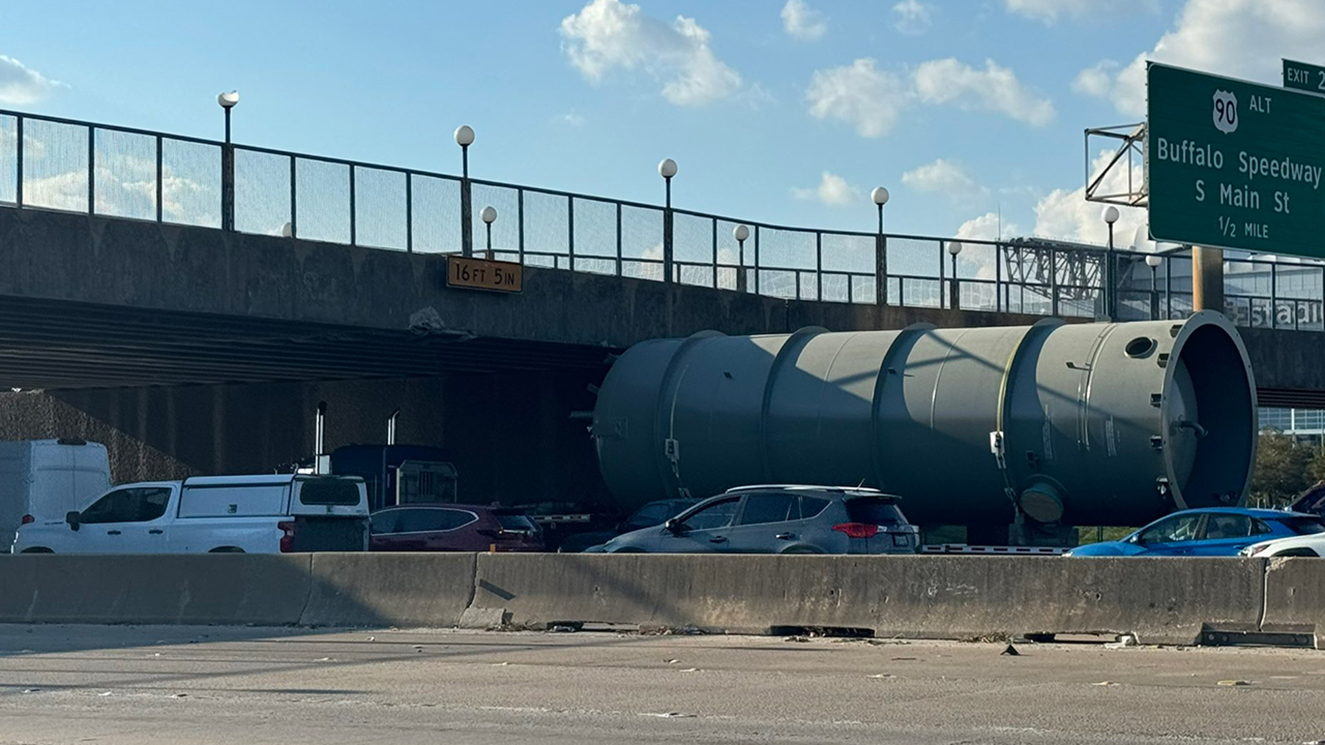 This is live video of the 610 South Loop, where a truck's load has hit the pedestrian bridge. Multiple lanes are shut down.