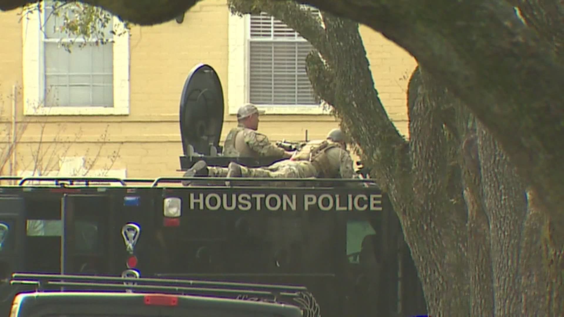 A seven-hour police standoff ended with two dead men, four escaped hostages and a suspect in custody Wednesday morning, Houston police said.