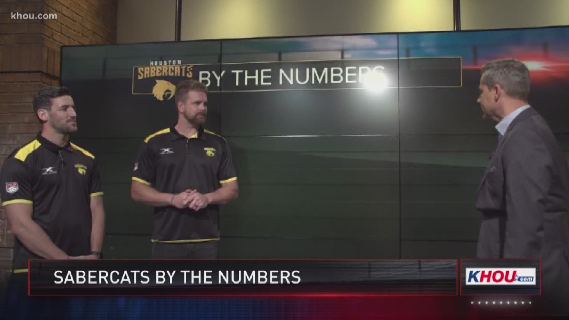KHOU 11 Sports anchor Jason Bristol talks numbers with Houston Rugby Sabercats players Sam Windsor and Matt Trouville. 