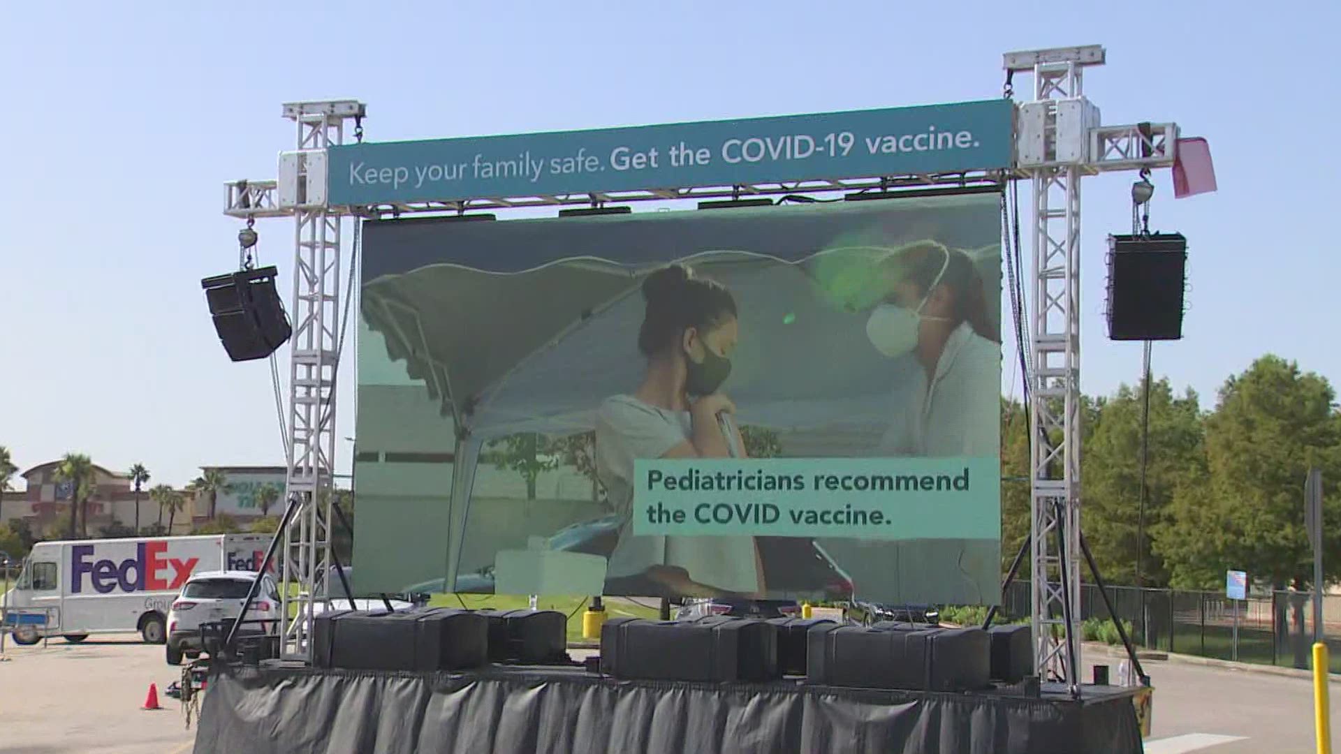 A 16-foot-tall video wall playing PSAs urges families to vaccinate their kids 12 and older ahead of the new school year.