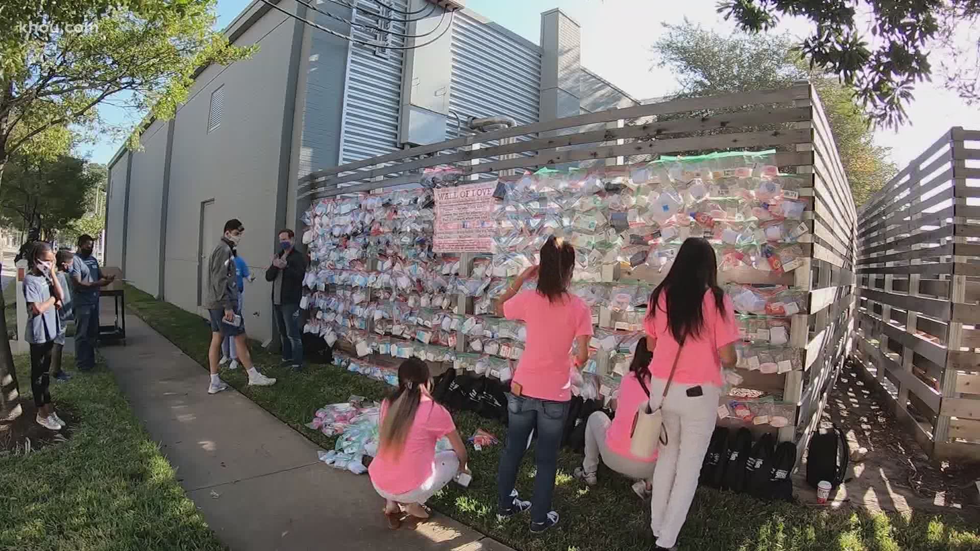 Dozens of volunteers spent the day placing hundreds of bags filled with essential supplies on the newly erected wall located on Jefferson Street.