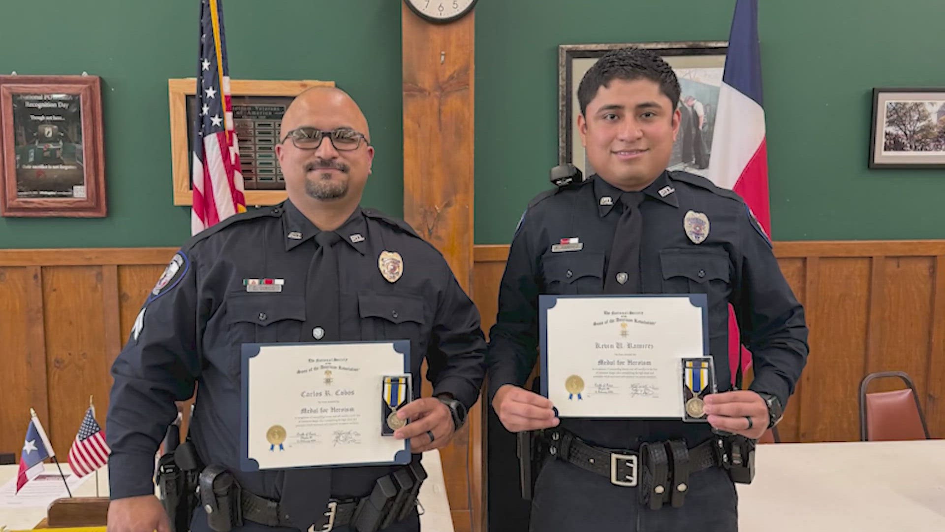 Two officers jumped into action and saved the life of a woman who was trapped inside an overturned vehicle that had caught on fire.