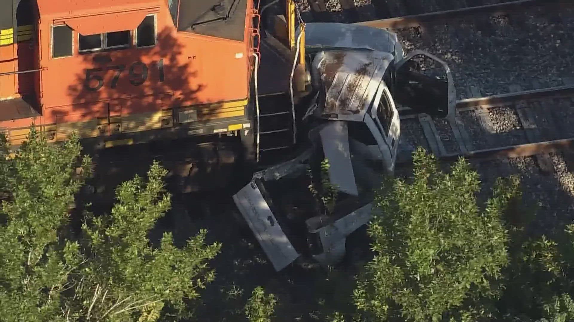 The train crashed into the truck on Mesa Drive. Views from Air 11 show a white pickup that appears to have been dragged for an extended distance along the tracks.