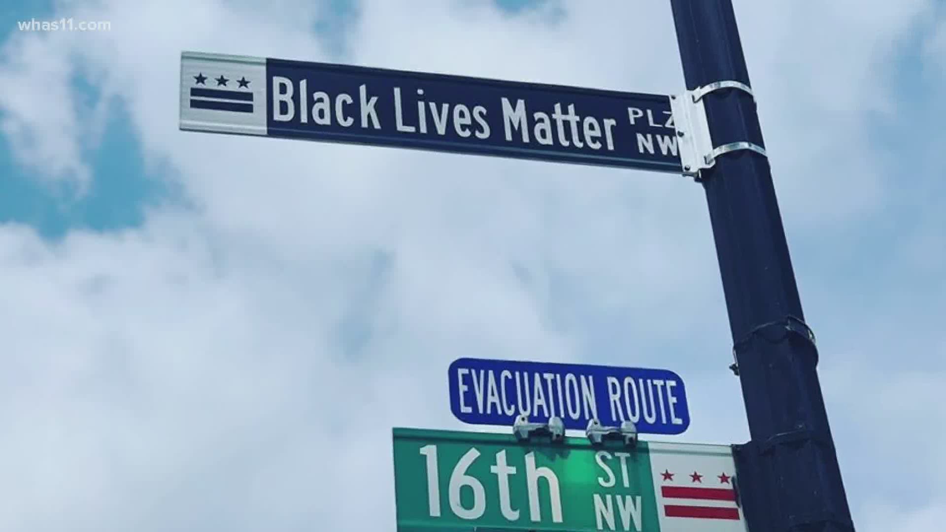 The words 'Black Lives Matter' in giant yellow letters span blocks of 16th Street.